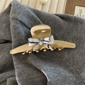 Detail of milk tea acetate hair claw clip with marble bow pattern and Creation France text