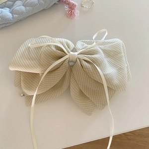 Elegant cream checkered bow hair claw with crystal pendant on light blue quilted bag