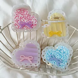 Set of four sweet heart-shaped acetate hair claws with lace edges and colorful patterns