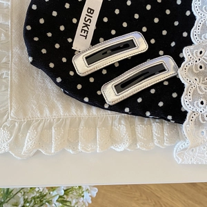 Minimalist silver and black rectangular BB hair clips on decorative lace background