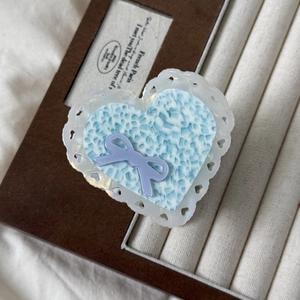 Detailed macro view of heart-shaped acetate hair claw clip with blue marble texture