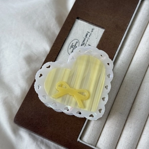 Detail of sweet yellow heart claw clip with lace edge and 3D bow on jewelry tray