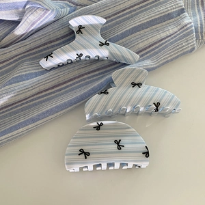 Three-piece set of blue striped acrylic hair claws with black bow patterns on white background