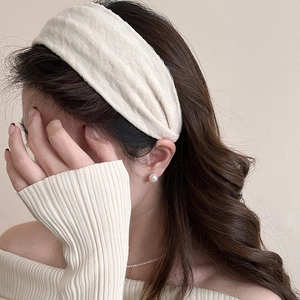 Detail of off-white chiffon headband with pleated texture on a model with elegant jewelry