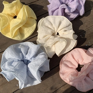 Set of large oversized pleated hair scrunchies in five pastel macaron colors on wood