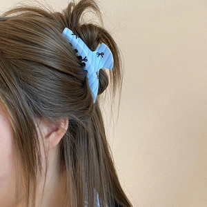 Blue striped claw clip with bow print shown on brown hair in a Korean hair style