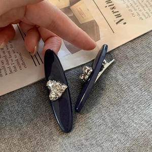 French style dark blue oval hair clips with silver rhinestone heart on grey background