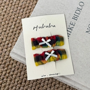 Dettaglio di fermagli per capelli vintage a quadri con fiocchi bianchi su carta