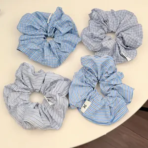 Set of four blue oversized striped and checkered scrunchies in minimalist Korean style