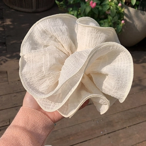 Close-up of cream oversized ruffled scrunchie with detailed fabric texture for hair