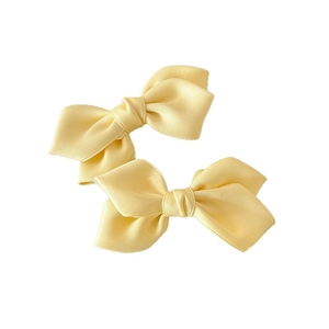 Paire de jolies barrettes nœuds jaunes pour femmes et filles sur fond blanc pur