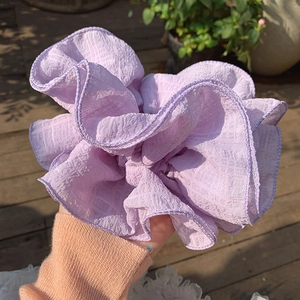 Macro detail of large purple seersucker scrunchie with fine plaid texture and ruffled design