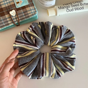 Detail shot of vintage knit striped hair scrunchie with soft rich texture and gray yellow tones