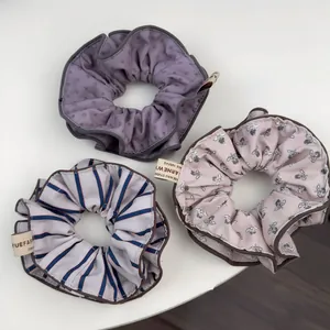 Détail de chouchous en tissu avec motifs à pois, fleurs et rayures sur fond blanc