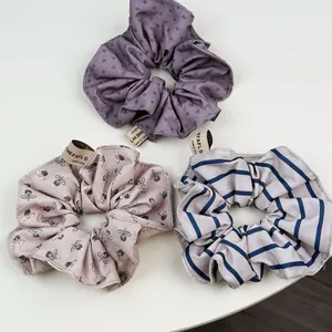 Gros plan détaillé de trois chouchous à volants avec motifs floraux et rayures bleues