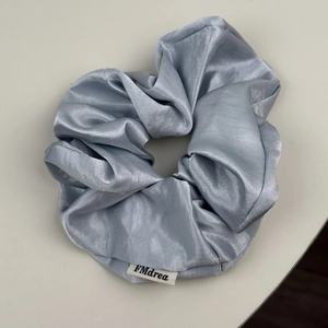 Chouchou géant en satin bleu-gris brillant avec texture soyeuse et étiquette de marque tissée