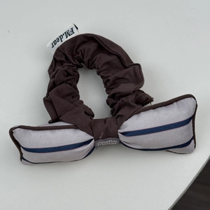 Détail du chouchou marron foncé avec un nœud rayé et une étiquette faite main