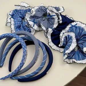 Serre-tête à carreaux bleus et chouchou en tissu assorti sur fond blanc épuré