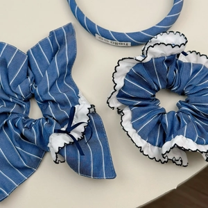 Détail d'un ensemble de bandeaux en tissu rayé bleu avec bords ondulés et nœud