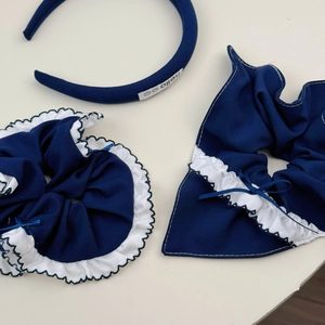 Détail du serre-tête à carreaux bleus et chouchous avec étiquette hello et dentelle
