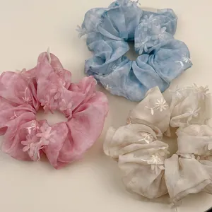 Set of mesh floral scrunchies in pink, blue, and beige with delicate 3D embroidery