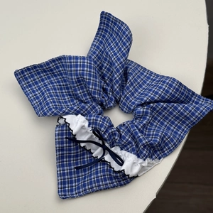 French blue plaid hair scrunchie with white lace trim and dark blue ribbon bow accent