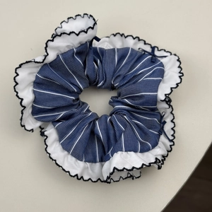 Detailed macro view of French blue plaid scrunchie with lace trim and bow knot