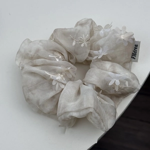 Detail of delicate 3D floral embroidery and translucent mesh texture on the hair scrunchie