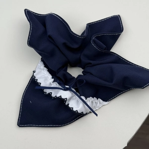 Detail of blue plaid lace scrunchie featuring a delicate bow and white pleated edges