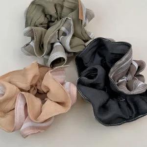 Three-piece oversized striped scrunchie set in olive green, peach pink, and charcoal black
