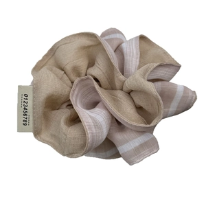 Oversized brown striped pleated scrunchie with a woven numeric label on a white background