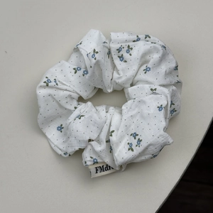 Chouchou à pois et fleurs blanches avec motifs floraux bleus et étiquette de marque