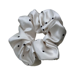 Chouchou élégant en satin blanc à pois noirs avec une texture soyeuse et lisse