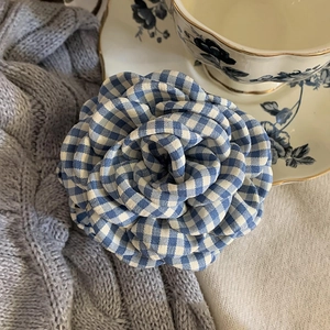 Detail of blue and white gingham fabric rose hair claw clip with vintage cotton texture