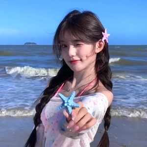 Barrettes étoile de mer bleues et roses portées par un mannequin sur fond de plage