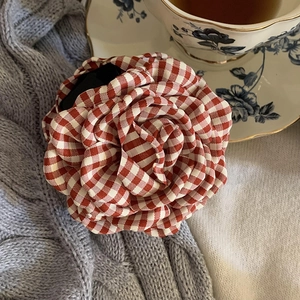 Close-up of red and white plaid fabric flower hair claw with intricate petal detail