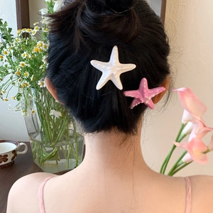 Barrettes à cheveux étoile de mer 3D en blanc et rose portées par un mannequin