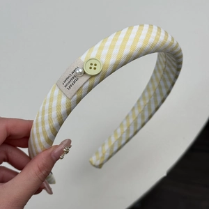 Gros plan détaillé du chouchou à carreaux jaunes avec bouton et perles décoratives