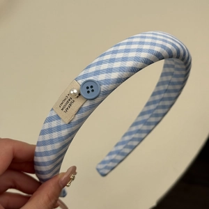 Détail d'un chouchou à carreaux bleus avec dentelle, perle blanche et bouton décoratif