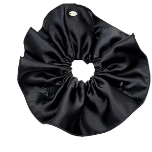 Elegant black satin scrunchie with a delicate bow and lucky gold charm detail
