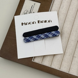 Set aus blauen Vintage-Karo- und schwarzen Stoff-Haarklammern auf weißer Karte