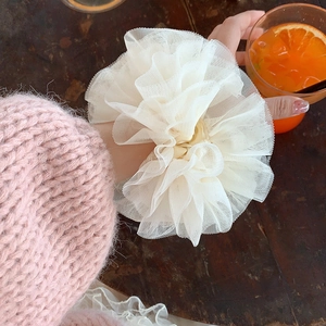 Gros plan sur le chouchou en dentelle blanche duveteuse porté au poignet style balletcore