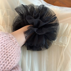 Vue détaillée d'un chouchou en tulle noir avec dentelle superposée sur le poignet