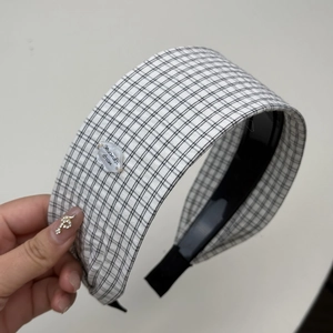 Détail d'un serre-tête large à carreaux avec étiquette nuage blanc et motif noir et blanc