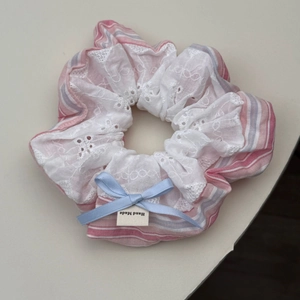 Detail of blue and pink striped scrunchie with white lace and handmade bow tie