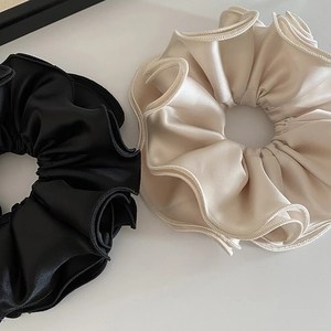Oversized four-layer satin scrunchies in black and champagne with elegant ruffled edges