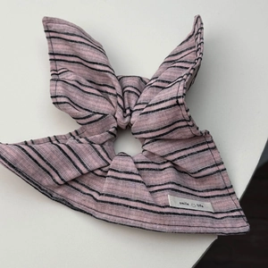 Detail van roze gestreepte scrunchie met konijnenoren en Smile Life geweven label