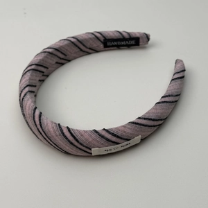 Detail van roze gestreepte haarband met handgemaakt label en smile life decoratief label