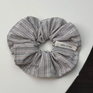 Detail van een gestreepte haarelastiek met smile life geweven label voor dames
