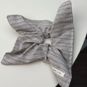 Detail van grijs gestreepte scrunchie met smile life label van katoenen materiaal